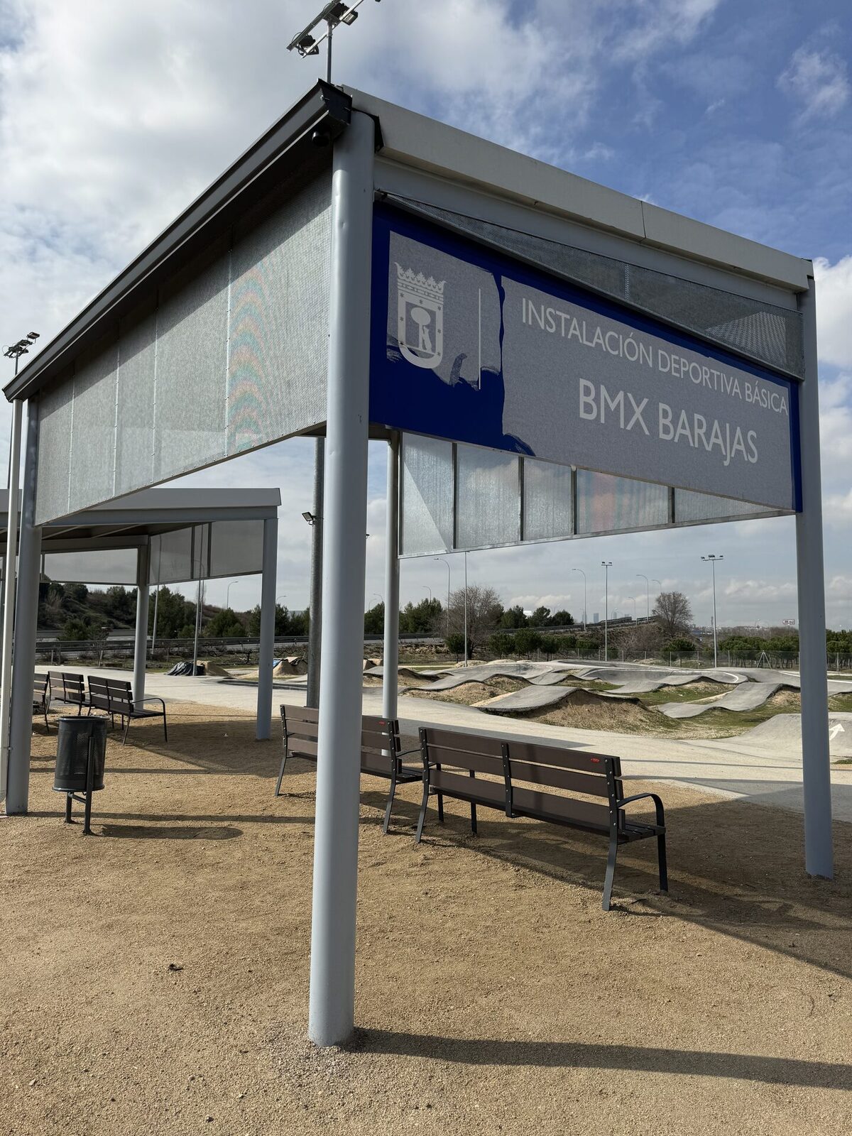 Sombraje metálico visto desde abajo, con bancos debajo