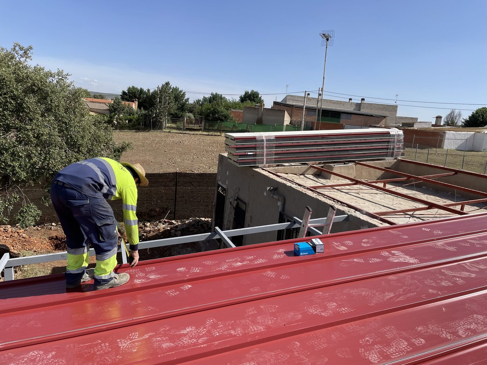 Operario colocando las chapas de la cubierta de una pérgola