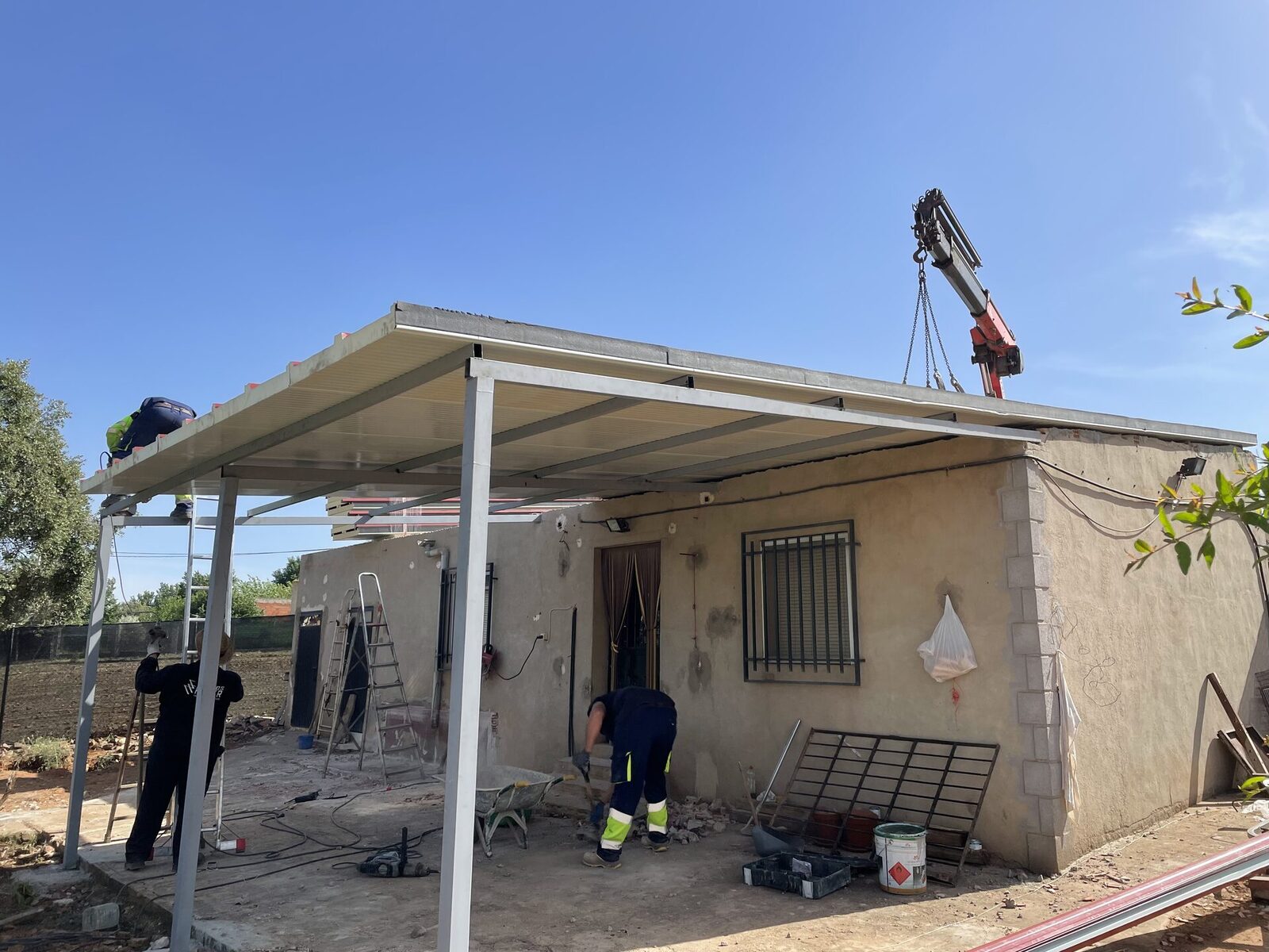Montaje de la estructura de una pérgola con ayuda de una grúa