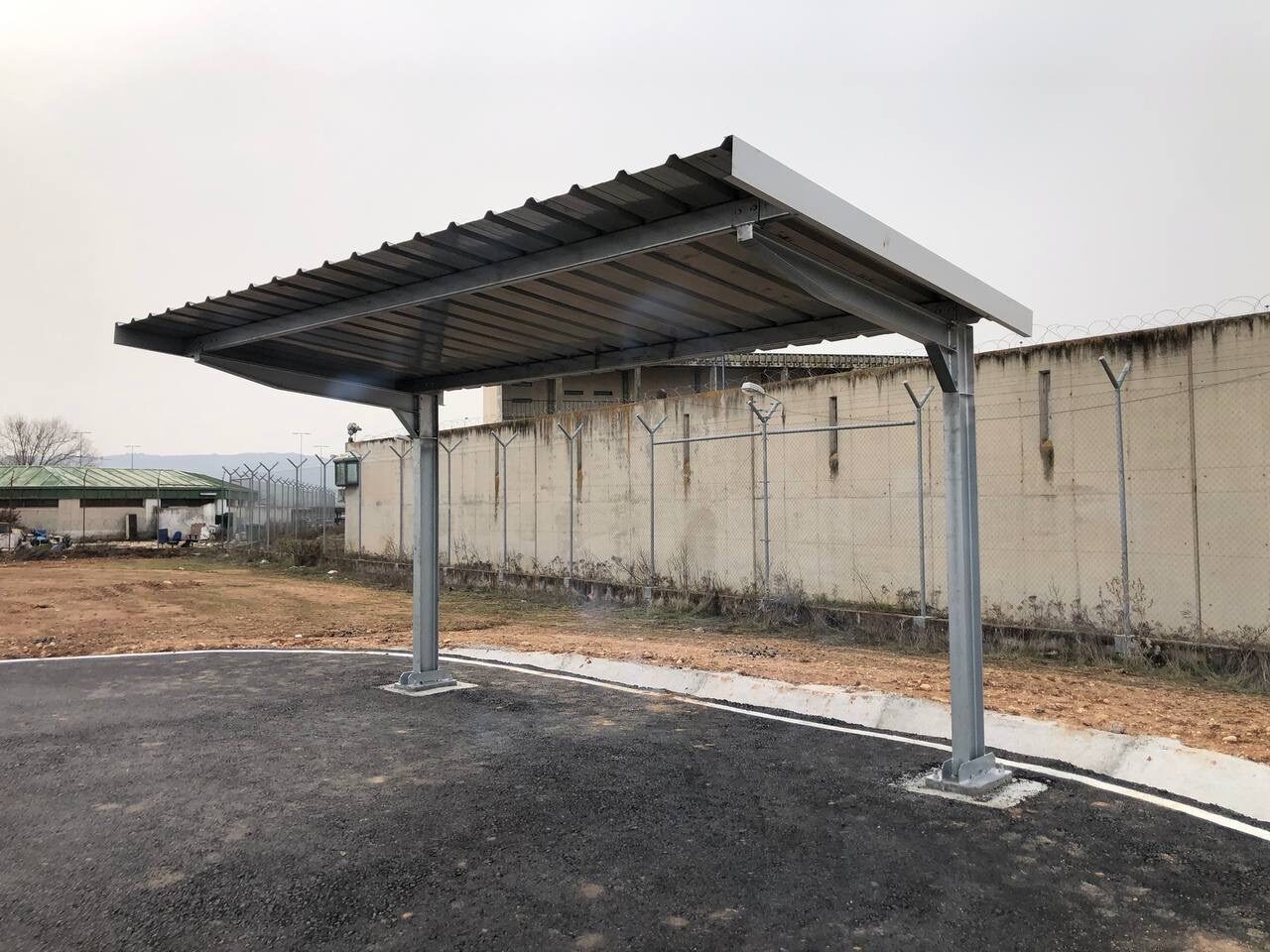 Sombraje para vehículos junto a un muro de hormigón