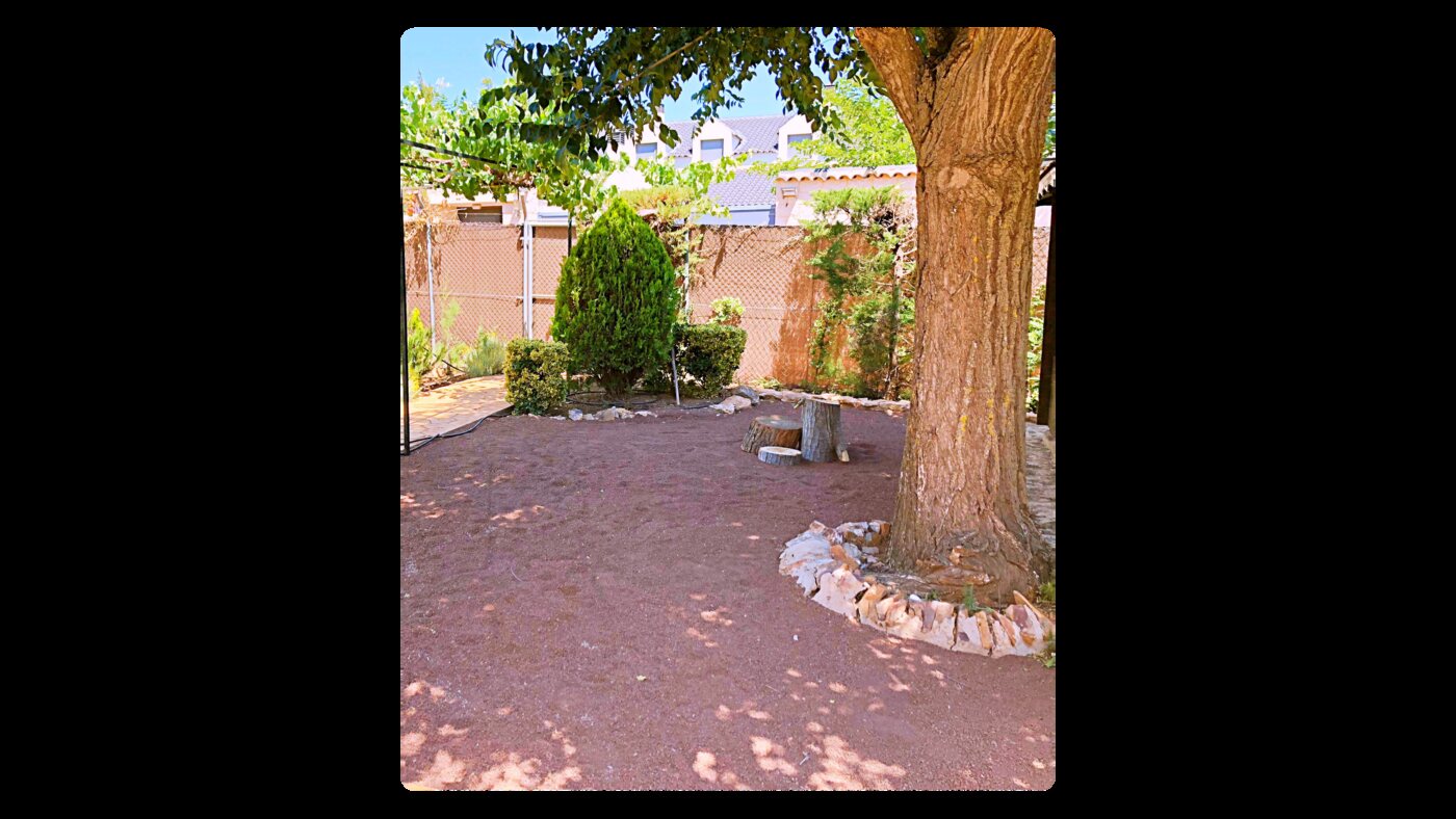 Jardín con zahorra roja alrededor de un árbol